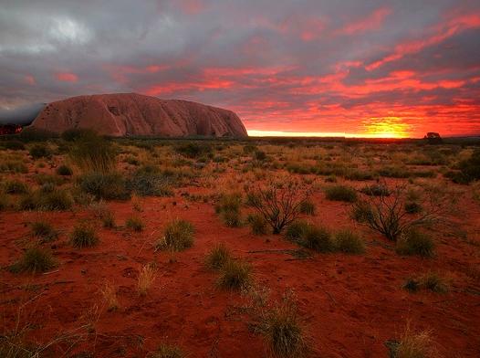 Practicing Yoga at Sunrise Against Uluru